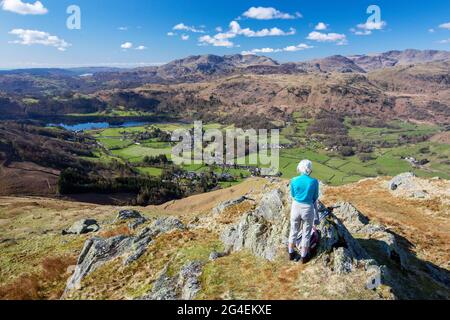 Un camminatore che guarda giù su Grasmere da Stone arthur sul lato di Fairfield, Lake District, UK. Foto Stock