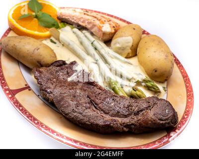Bistecca di manzo con asparagi verdi e salmone Foto Stock