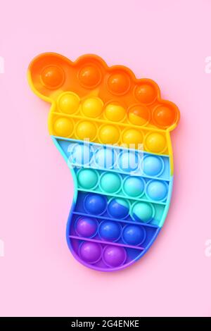 Colorful antistress sensoriale giocattolo fidget spingere pop esso su sfondo rosa, vista dall'alto Foto Stock
