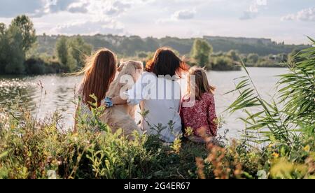 Famiglia con Golden Retriever cane all'aperto Foto Stock