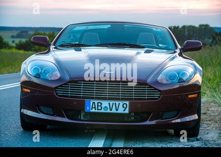 Bella, elegante Aston Martin DB9 Volante convertibile sulla strada al tramonto Foto Stock