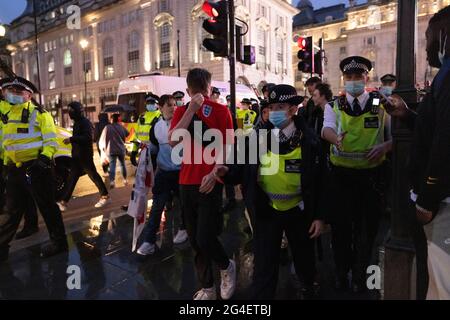 Gli appassionati di calcio inglesi si sono mossi da ufficiali della polizia MET nel West End, nel centro di Londra, in vista della partita EURO20 contro la Scozia. Foto Stock