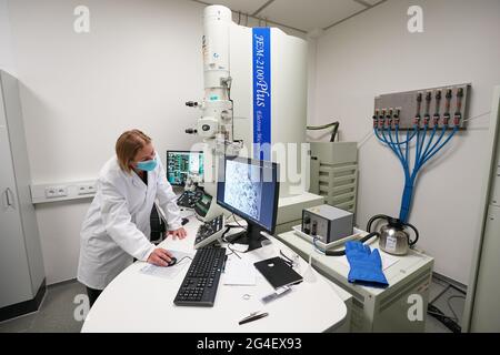 Schenefeld, Germania. 21 Giugno 2021. Kristina Lorenzen, responsabile e scienziato di laboratorio, guarda un quadro delle proteine attraverso un microscopio elettronico nel laboratorio biologico XBI del campus della struttura internazionale di ricerca europea XFEL. Tra le altre cose, vi si sta svolgendo una ricerca sulla struttura di una proteina che porta il coronavirus nel suo involucro. La XFEL europea gestisce il laser a raggi X più grande del mondo. Credit: Marco Brandt/dpa/Alamy Live News Foto Stock