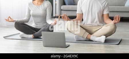 Corto di giovane coppia che pratica yoga a casa Foto Stock