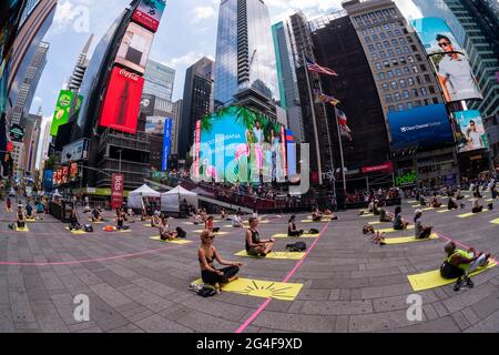 Praticanti di yoga socialmente distanti impacchettare Times Square a New York per praticare lo yoga sul solstizio estivo, primo giorno d'estate, domenica, 21 giugno 2021. L'annuale Solstice in Times Square, 'Mind Over Madness', sponsorizzato da Eyrie, il Consolato Generale dell'India, New York e Smartwater, amplia la capacità degli yogi di bloccare il rumore e l'ingombro visivo che li circondano nelle Crossroads del mondo. Il primo giorno d'estate è stato dichiarato dalle Nazioni Unite la Giornata Internazionale dello Yoga. (ÂPhoto di Richard B. Levine) Foto Stock