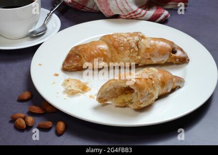 Croissant alle mandorle su piatto con caffettiera, Germania Foto Stock