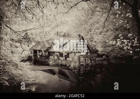 Immagine a infrarossi, storico mulino a martelli, museo, fonte carsica del Blau, Blautopf in Blaubeuren, Alb sveva, Baden-Wuerttemberg, Germania Foto Stock