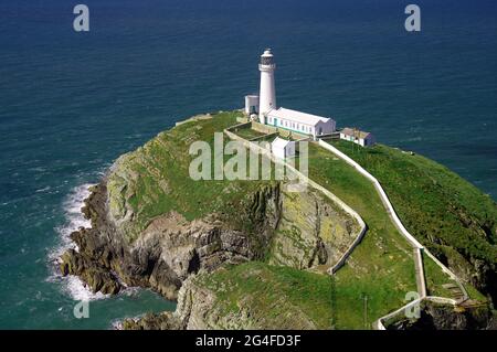 Faro bianco su isola rocciosa, mare, South Stack, Holyhead, Galles Gran Bretagna Foto Stock