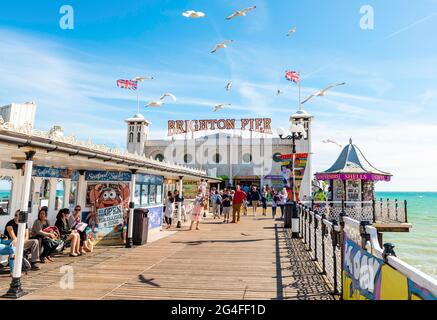 Turisti al Brighton Palace Pier con gabbiani, Brighton, East Sussex, Inghilterra, Regno Unito Foto Stock