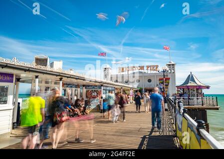 Turisti a Brighton Palace Pier con gabbiani, esposizione lunga, Brighton, Sussex Est, Inghilterra, Regno Unito Foto Stock