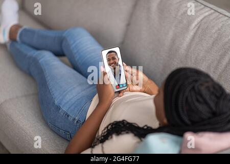 Donna afroamericana con smartphone, parlando con un medico Foto Stock