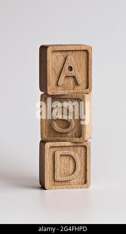 Foto verticale sul tema ASD (disturbi dello spettro autistico). Cubi di legno con l'abbreviazione 'ASD', su sfondo bianco Foto Stock