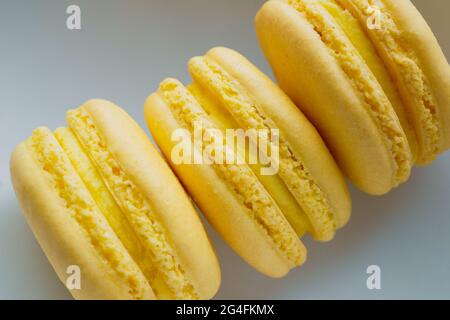 Tre macaron francesi al limone di colore giallo appena sfornati Foto Stock