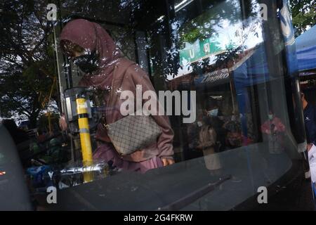 Nel mezzo della minaccia di un aumento dei casi di Covid-19 nella regione capitale speciale di Giacarta, un certo numero di lavoratori si è accodato a salire a bordo dell'autobus Trans Jakarta per recarsi nei rispettivi uffici al di fuori della stazione ferroviaria di Manggarai, Giacarta meridionale, Indonesia, lunedì 21 giugno; 2021. I decessi dovuti al Covid-19 a Giacarta sono aumentati di nuovo. Ai cittadini della regione capitale speciale di Giacarta viene chiesto di continuare ad aumentare la loro vigilanza contro il tasso di aggiunta dei casi di Covid-19. Ora i casi totali in Indonesia hanno raggiunto 2 milioni di casi, con la regione capitale speciale di Giacarta che è Foto Stock