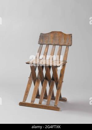 . Sedia pieghevole in legno di faggio, con cinque doghe nello schienale e nove nel sedile. Il solido superiore del retro mostra una semplice decorazione tagliata a tacca con un giglio tagliato a metà. Foto Stock
