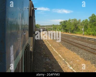 treno e treno nelle vicinanze in una zona collinare con sfondo blu cielo Foto Stock