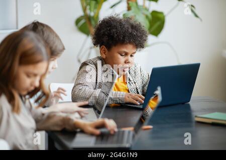 Diversi gruppi di bambini che utilizzano il computer durante la lezione DI INFORMATICA a scuola Foto Stock