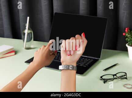 Bella donna curata mani su tavola verde. Accessori estivi femminili Foto Stock