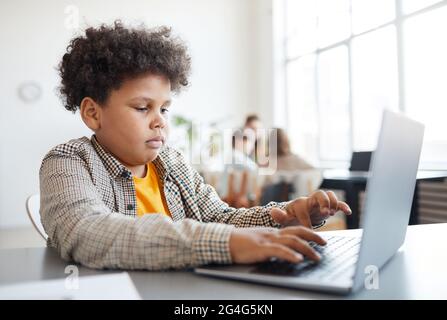 Vista laterale ritratto di alunni afroamericani utilizzando un computer portatile in classe, spazio di copia Foto Stock