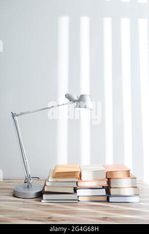 Molti studenti libri su grande tavolo con lampada moderna Foto Stock