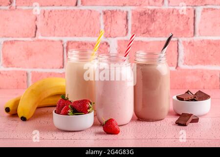 Set di fragole banana e cioccolato milkshake nei vasi di vetro Foto Stock