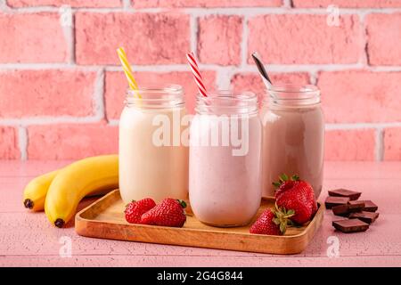Set di fragole banana e cioccolato milkshake nei vasi di vetro Foto Stock