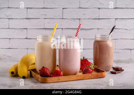 Set di fragole banana e cioccolato milkshake nei vasi di vetro Foto Stock