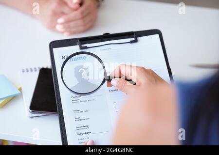 Datore di lavoro che guarda il lavoratore riprendere con ingrandimento closeup di vetro Foto Stock