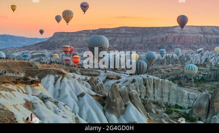 Cappadocia, 05,2018 ottobre: I turisti osservano i colorati bolloni ad aria calda che decolla la mattina presto dalla campagna a Cappadocia, Goreme, Turchia Foto Stock