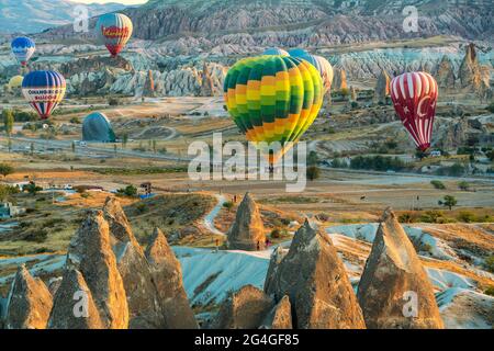 Cappadocia, 05 ottobre 2018: Palloncini colorati ad aria calda che volano sopra formazioni rocciose di campagna al mattino presto a Cappadocia, Goreme, Turchia Foto Stock