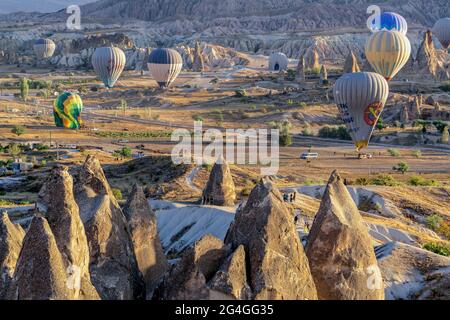 Cappadocia, 05 ottobre 2018: Palloncini colorati ad aria calda che volano sopra formazioni rocciose di campagna al mattino presto a Cappadocia, Goreme, Turchia Foto Stock