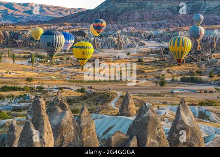 Cappadocia, 05 ottobre 2018: Palloncini colorati ad aria calda che volano sopra formazioni rocciose di campagna al mattino presto a Cappadocia, Goreme, Turchia Foto Stock