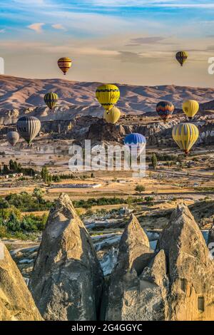 Cappadocia, 05 ottobre 2018: Palloncini colorati ad aria calda che volano sopra formazioni rocciose di campagna al mattino presto a Cappadocia, Goreme, Turchia Foto Stock