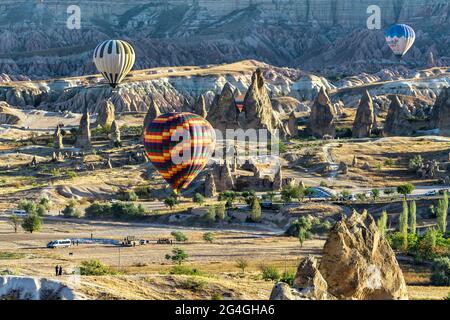 Cappadocia, 05 ottobre 2018: Palloncini colorati ad aria calda che volano sopra formazioni rocciose di campagna al mattino presto a Cappadocia, Goreme, Turchia Foto Stock