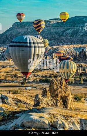 Cappadocia, 05 ottobre 2018: Palloncini colorati ad aria calda che volano sopra formazioni rocciose di campagna al mattino presto a Cappadocia, Goreme, Turchia Foto Stock