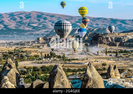 Cappadocia, 05 ottobre 2018: Palloncini colorati ad aria calda che volano sopra formazioni rocciose di campagna al mattino presto a Cappadocia, Goreme, Turchia Foto Stock