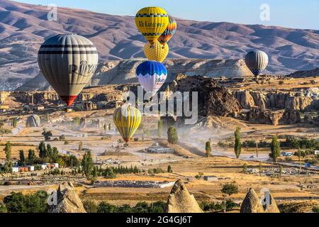 Cappadocia, 05 ottobre 2018: Palloncini colorati ad aria calda che volano sopra formazioni rocciose di campagna al mattino presto a Cappadocia, Goreme, Turchia Foto Stock