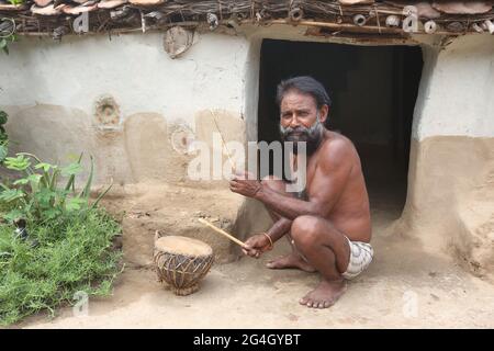 TRIBÙ KOL. House - musicista tribale di Kol che suona Lagaria un tamburo musicale tradizionale come strumento. Villaggio di Bhanpur di Huzur Tehsil a Rewa Dist, Madhy Foto Stock