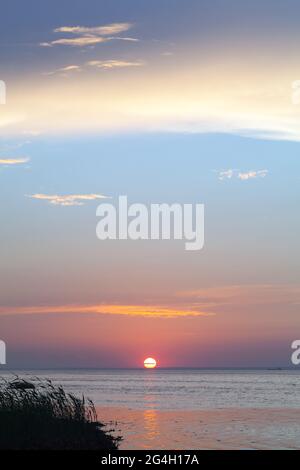 Tramonto colorato sul Mar Baltico in una serata estiva, foto verticale Foto Stock