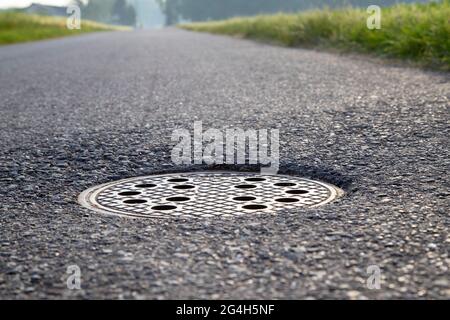 primo piano di una copertura di tombino in asfalto Foto Stock