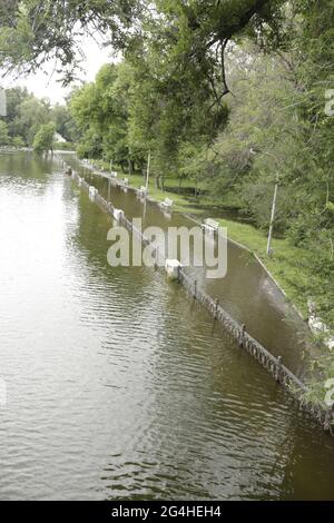 Parco pubblico pieno di pioggia. Panchine Park.Wet con loggato d'acqua. Parcheggio pieno d'acqua dopo la pioggia.parcheggio vuoto dopo pioggia pesante. Foto Stock