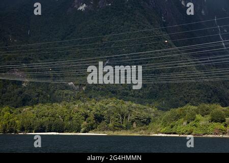 Linee elettriche dalla centrale elettrica di Manapouri e dalla foresta nativa, dal lago Manapouri, dal parco nazionale di Fiordland, dall'isola meridionale, Nuova Zelanda Foto Stock