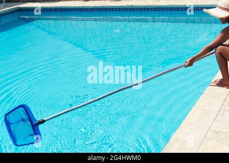 Donna, personale che pulisce la piscina Foto Stock