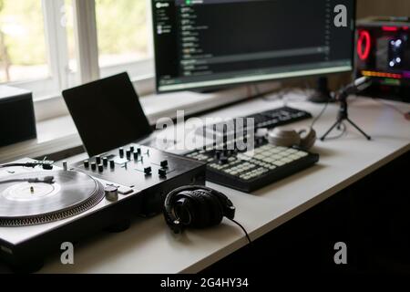 piccolo studio di produzione musicale primo piano, lettore di dischi, mixer midi drum pad e microfono Foto Stock