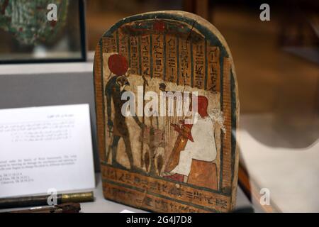 Il Cairo. 21 Giugno 2021. Foto scattata il 21 giugno 2021 mostra una stela funeraria raffigurante un arpista che suona uno strumento di fronte alla divinità Ra-Horakhty in una mostra al Cairo, Egitto. Una collezione di 22 strumenti musicali antichi è in mostra al Museo Egizio di Tahrir del Cairo per celebrare la Giornata Mondiale della Musica, una celebrazione musicale annuale che si svolge il 21 giugno. Credit: Ahmed Gomaa/Xinhua/Alamy Live News Foto Stock