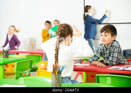 Ritratto di scolari seduta in Aula e chiacchierando durante la lezione Foto Stock