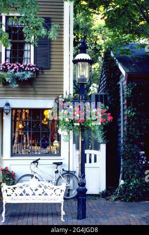 Negozio di biciclette, lampione con fiori e panca bianca sull'isola di Nantucket, Massachusetts Foto Stock