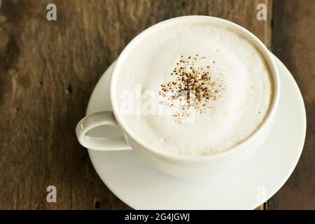 cappuccino in tazzina bianca su fondo di legno Foto Stock