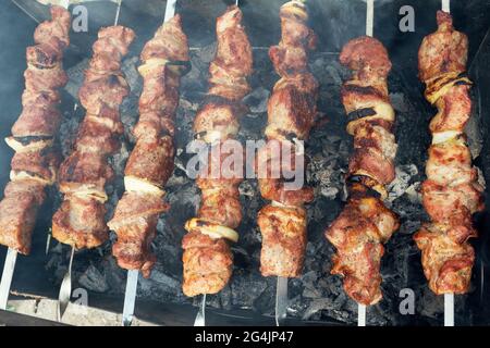 Marinata di spiedini preparazione su un grill barbecue a carbone. Spiedini o shish kebab popolare in Europa orientale. Shashlyk (spiedini di carne) era origine Foto Stock