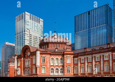 Giappone tra tradizione e modernità. Gli edifici moderni del centro della città sono la facciata e la cupola in mattoni rossi della vecchia ed elegante stazione ferroviaria Foto Stock